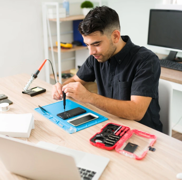 A technician repairing a phone on a clean tech bench